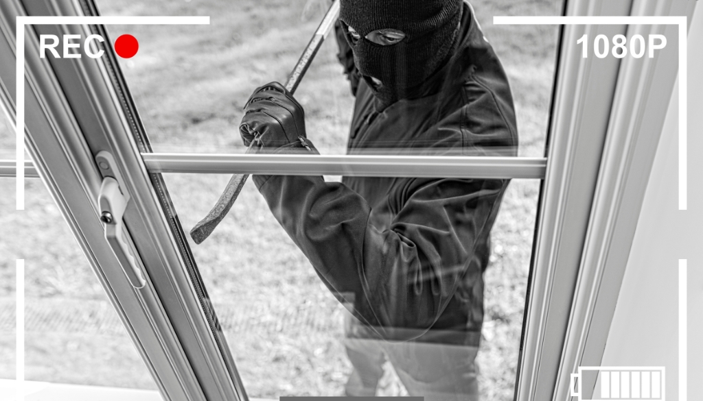 A man committing theft by breaking into a locked building.