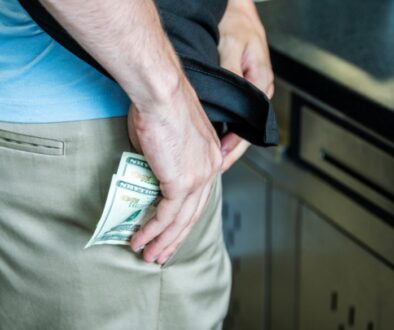 An employee committing internal theft by stealing money.