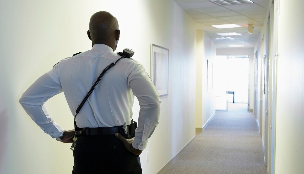 A security guard patrolling an office hallway.