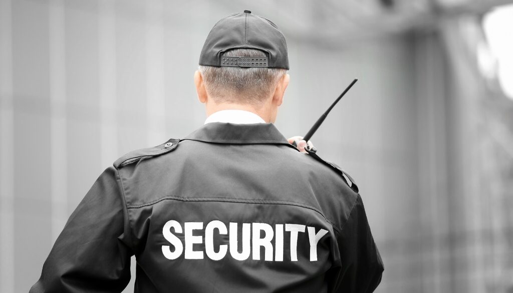 Security guard talking into a walkie-talkie.