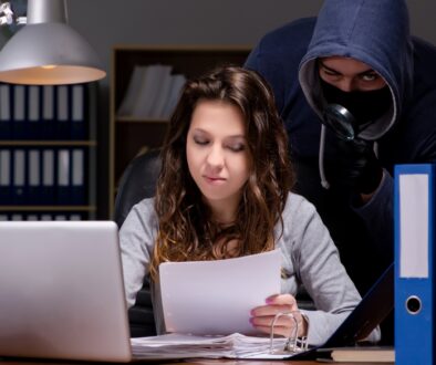 Masked man stands behind woman on computer. Empower your safety tips.