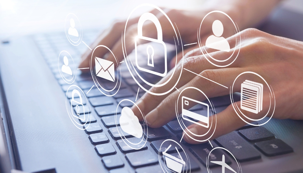 obrien-associates-year-end-security-protocol-review (2) Person typing on a laptop with digital security icons.
