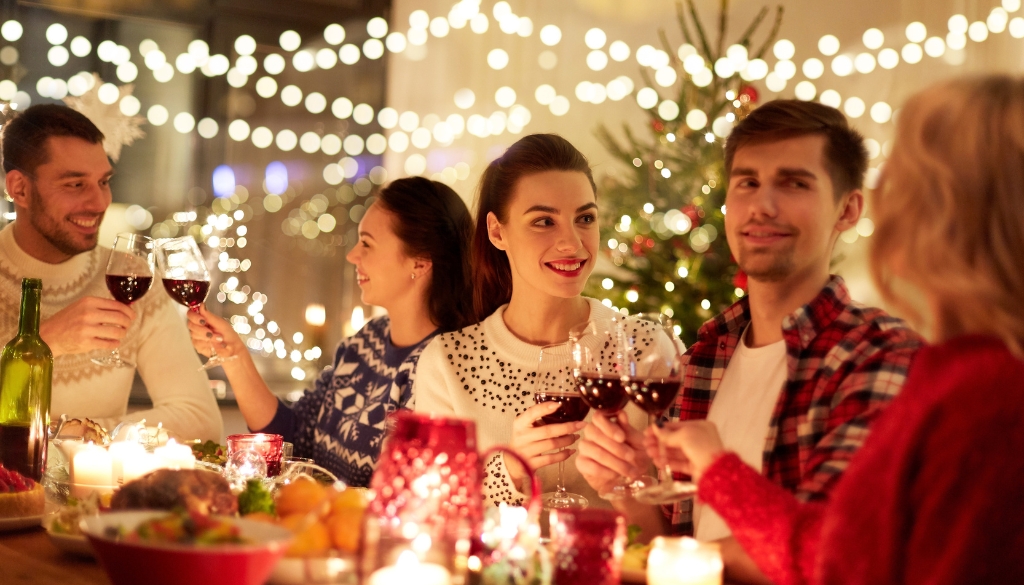 People cheering with wine during a holiday party.