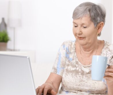 Elderly woman working on a laptop.