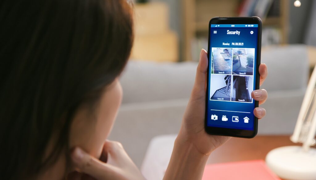 Woman watching a live video home security monitor on her phone.