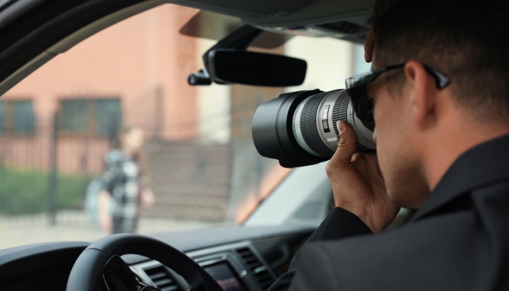 Private investigator watches a suspect in a skip locate service investigation.