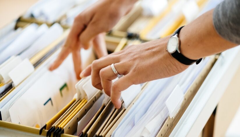 Person sifting through a file cabinet.