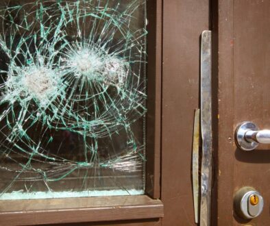 Front doors of a building with shattered glass.