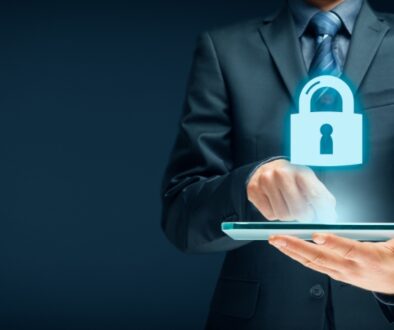 Businessman in a suit holidng an iPad with a lock graphic icon above it.