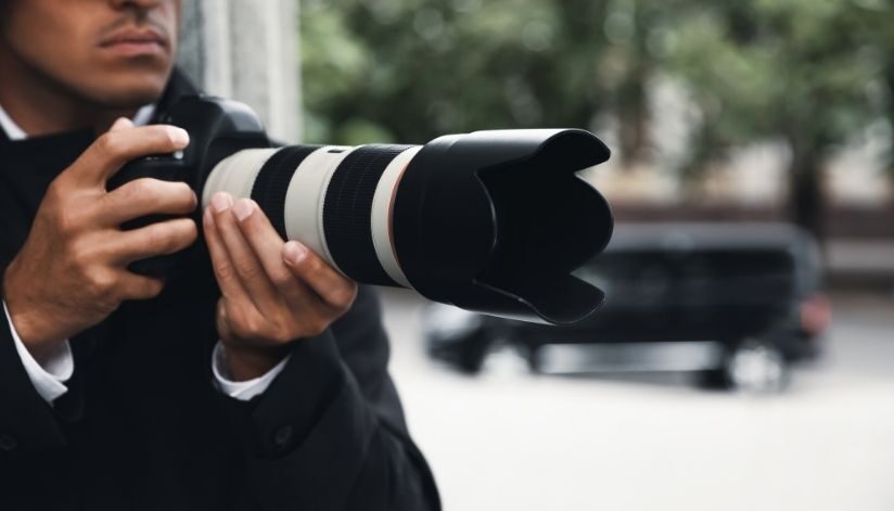 o'brien-&-associates-private-investigator-proces-man-holds-camera-photo-van