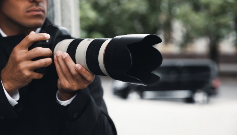 o'brien-&-associates-private-investigator-proces-man-holds-camera-photo-van