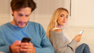 o'brien-&-associates-suspecting-partner-of-infidelity-couple-distressed-on-couch-looking-on-phone