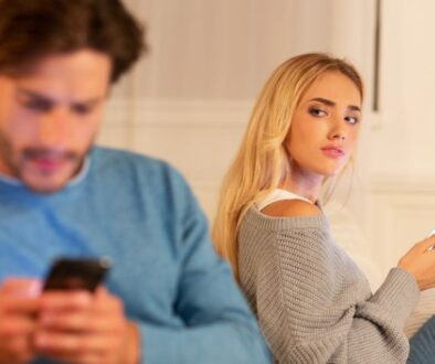 o'brien-&-associates-suspecting-partner-of-infidelity-couple-distressed-on-couch-looking-on-phone