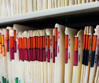 File folders on a shelf organized in alphabetical order.