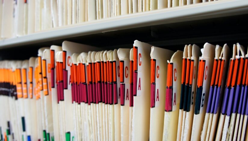 File folders on a shelf organized in alphabetical order.
