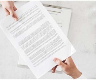 Two hands hold a document on either end.
