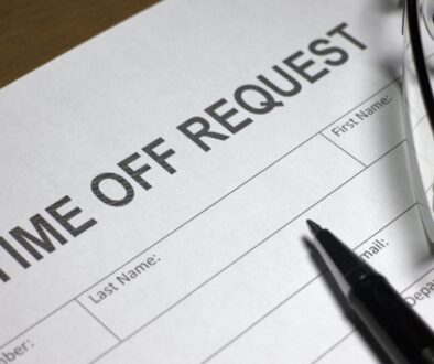 A time off request document with a pen resting on the paper in preperation for business security planning.