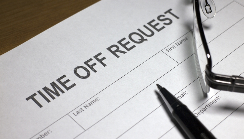 A time off request document with a pen resting on the paper in preperation for business security planning.