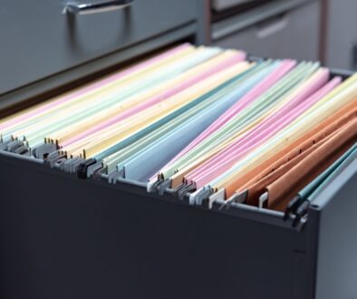 A black filing cabinet drawer opened to organized business documentation.