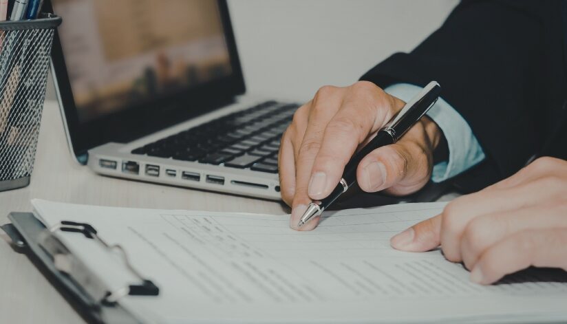 Business owner reviews security preparedness of documents on a clipboard.